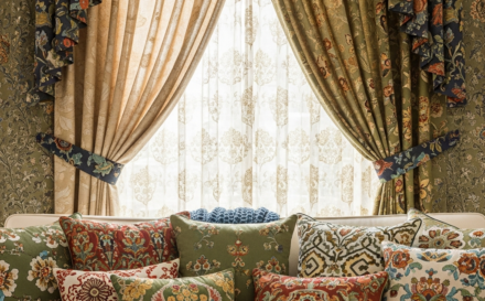 A beautiful living room arrangement with cushions and curtains in various patterns.